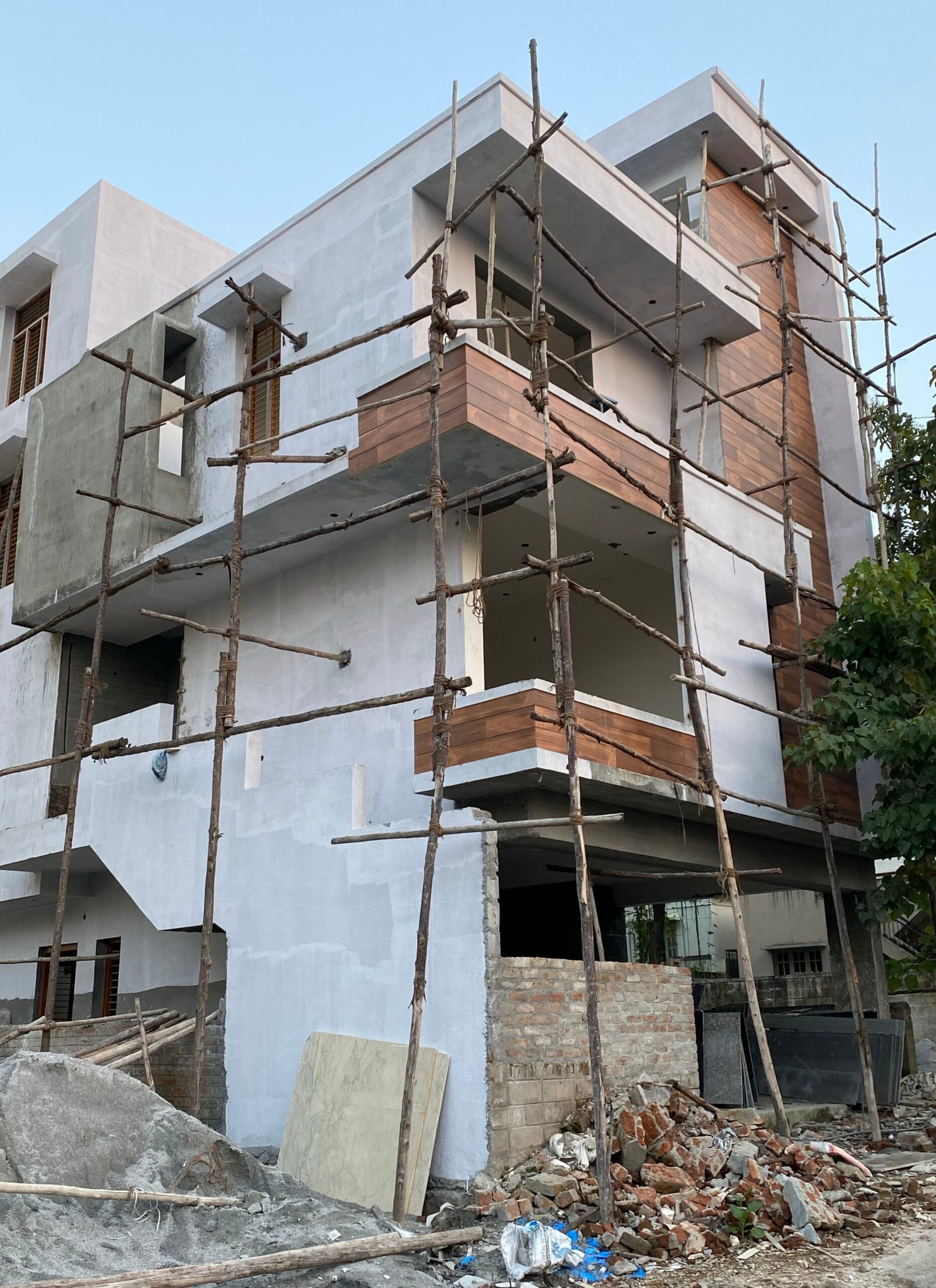 Woning in aanbouw met steigers en onafgewerkte muren voor renovatie.