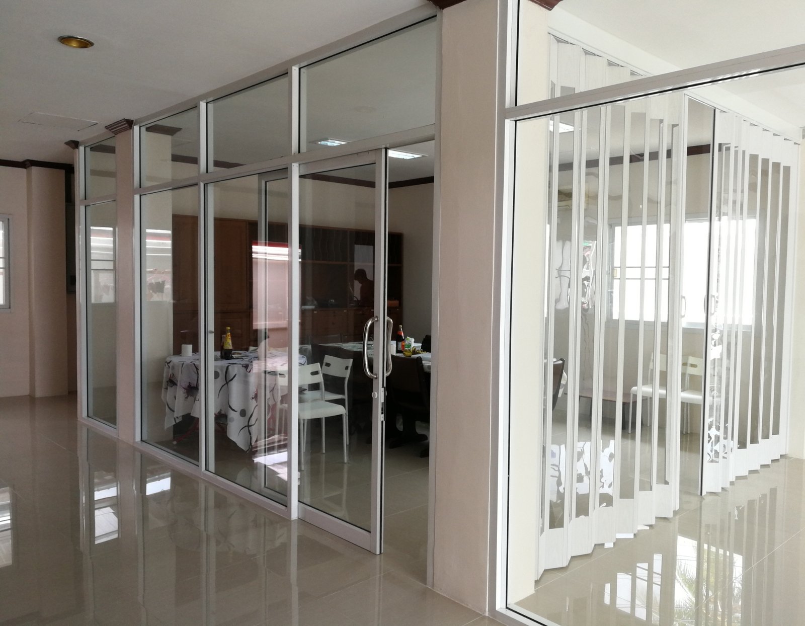 innenaanzicht van een modern kantoor met glazen wanden en schuiframen.